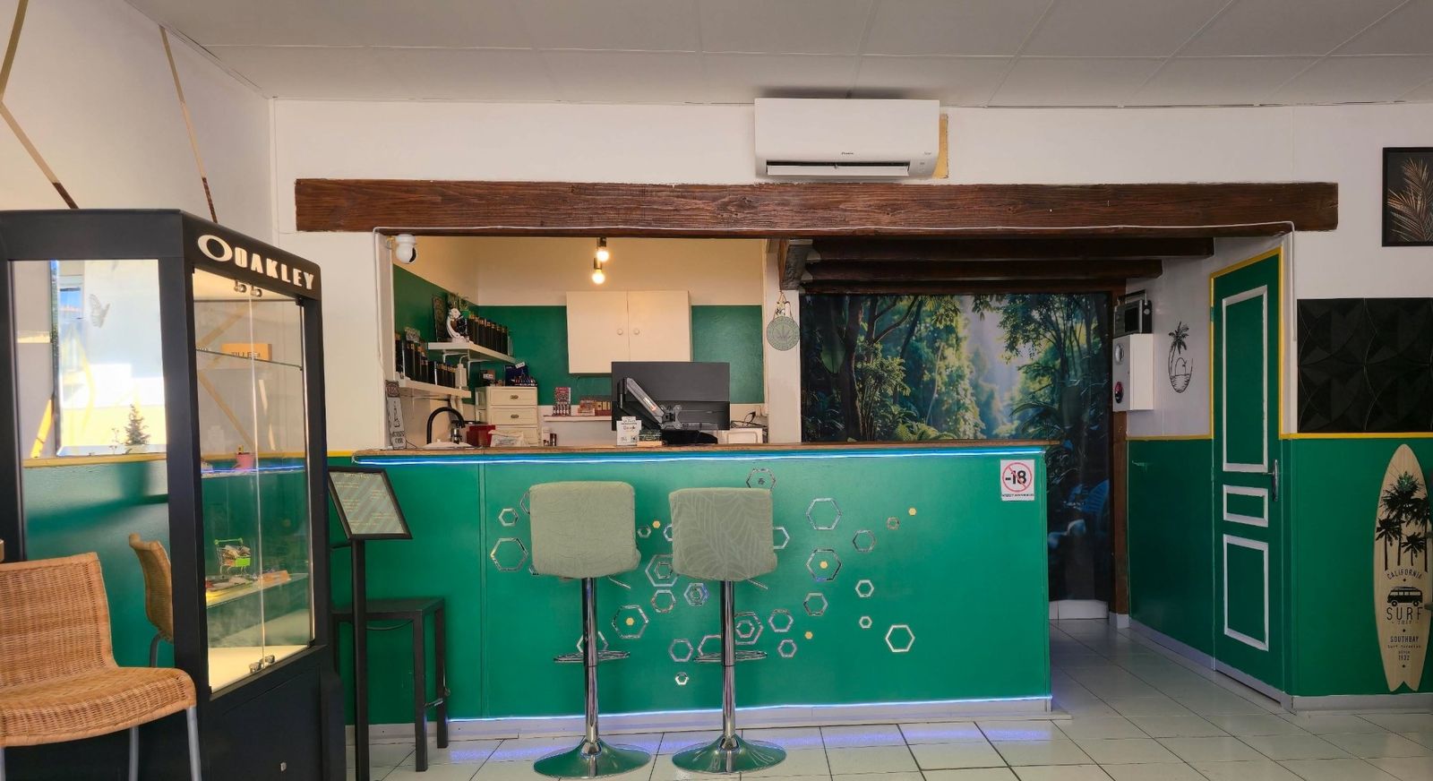 Le comptoir de la boutique Green Labs, murs vert émeraude et décor de jungle